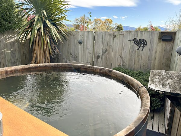 A hot tub with privacy screen and native plantings at Musterer's Accommodation, Fairlie.