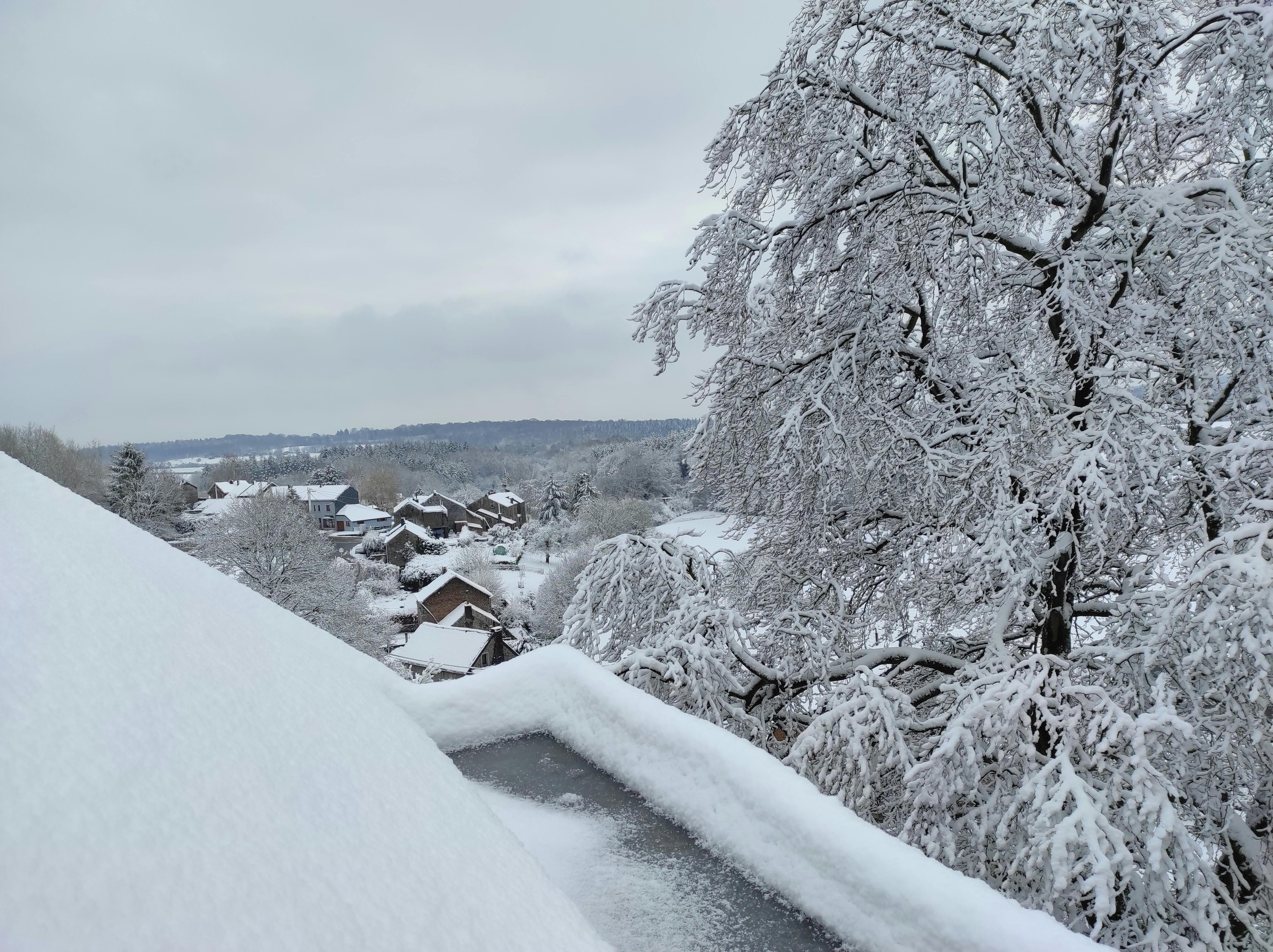 View of the snowy landscape of the Ourthe Valley from the window of a room at La Maison Vienvenue, a cycling accommodation.