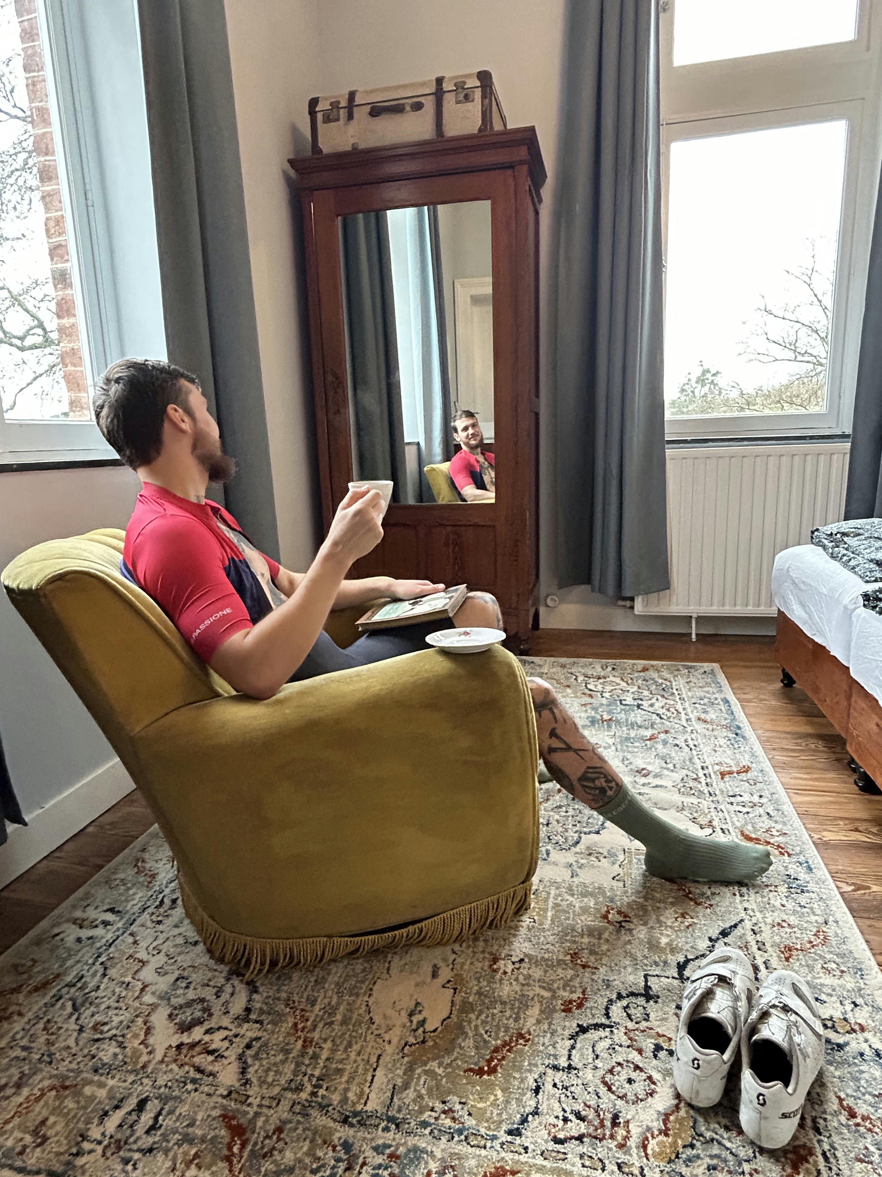 Hipster cyclist drinking coffee in a room for cyclists at La Maison Vienvenue.