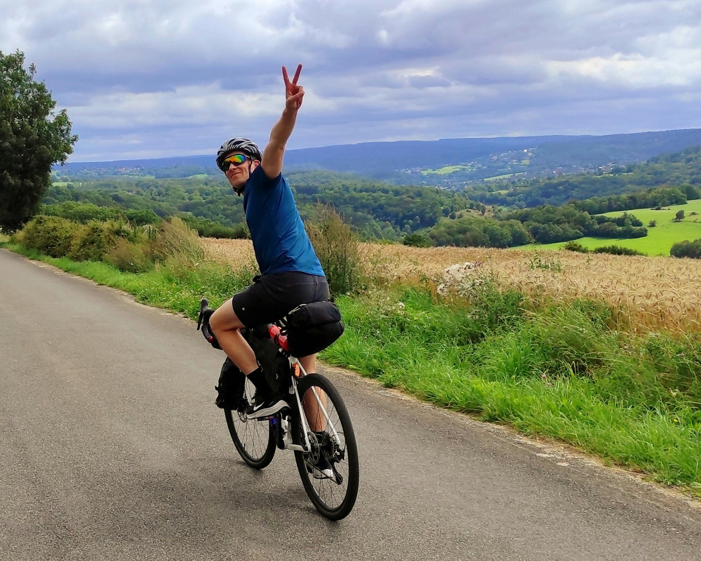 Cyclist conquering a challenging hill on one of La Maison Vienvenue's recommended cycling routes.