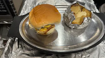 "Grilled cheese burger served with a loaded baked potato."