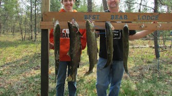alt="Guest showing off a large fish caught at Best Bear Lodge & Campground in Irons Michigan"