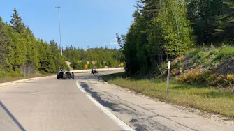 Driving a Polaris Slingshot through the scenic winding roads of Manistee National Forest near Best Bear Resort.