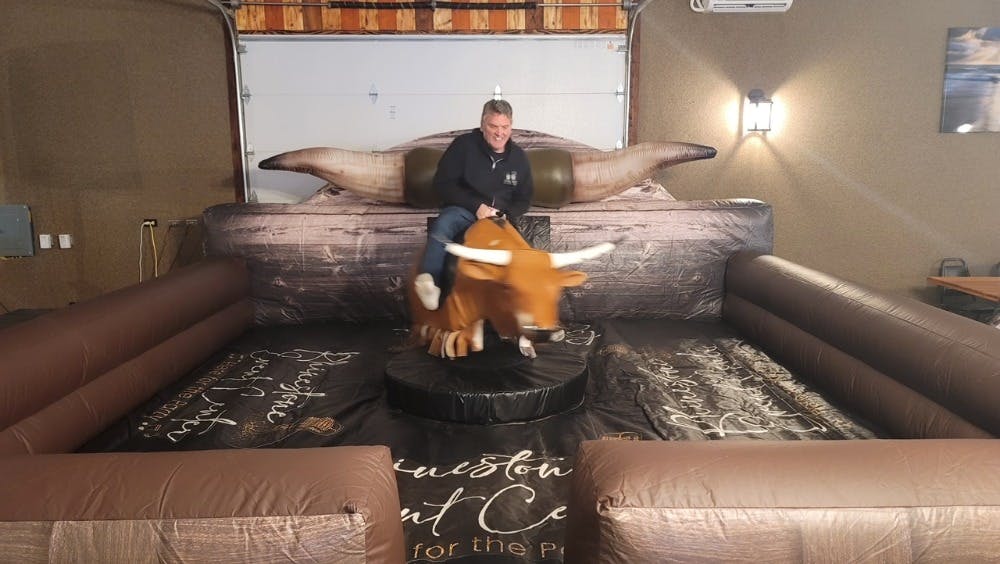Matt Bearup riding Billy the mechanical bull in the Rhinestone Event Center at Best Bear Lodge Irons, Michigan