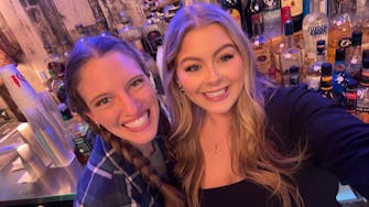 "Bri and Morgan, the Rhinestone Bartenders, serving drinks at a Waylon Hanel country music performance."