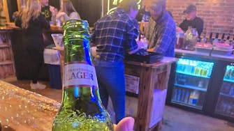 "Close-up of a customer holding a bottle of Yuengling Golden Pilsner."