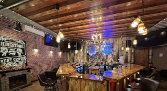 Rhinestone bar sign overlooking beer, wine, and liquor bottles.