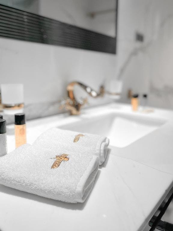 Modern bathroom sink with rolled towels and amenities