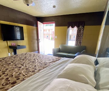 king, king bedroom, kitchenette, refrigerator, microwave, stove top, cooktop, table, chairs, bed, private room