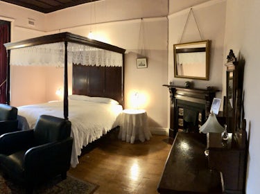 Deluxe Queen room with lounge chairs and smart TV 1