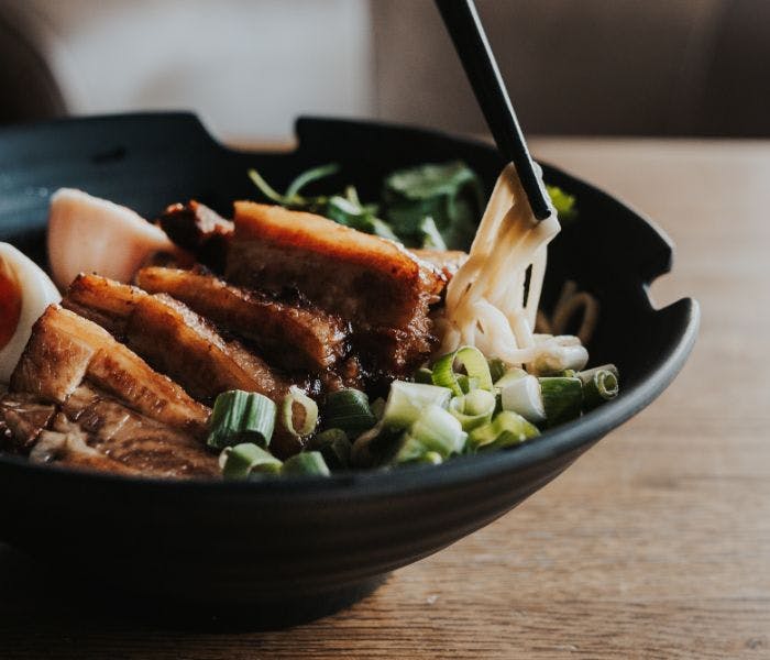 A delicious bowl of ramen with slices of meat and boiled eggs.