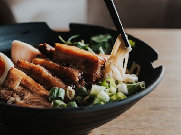 A delicious bowl of ramen with slices of meat and boiled eggs.