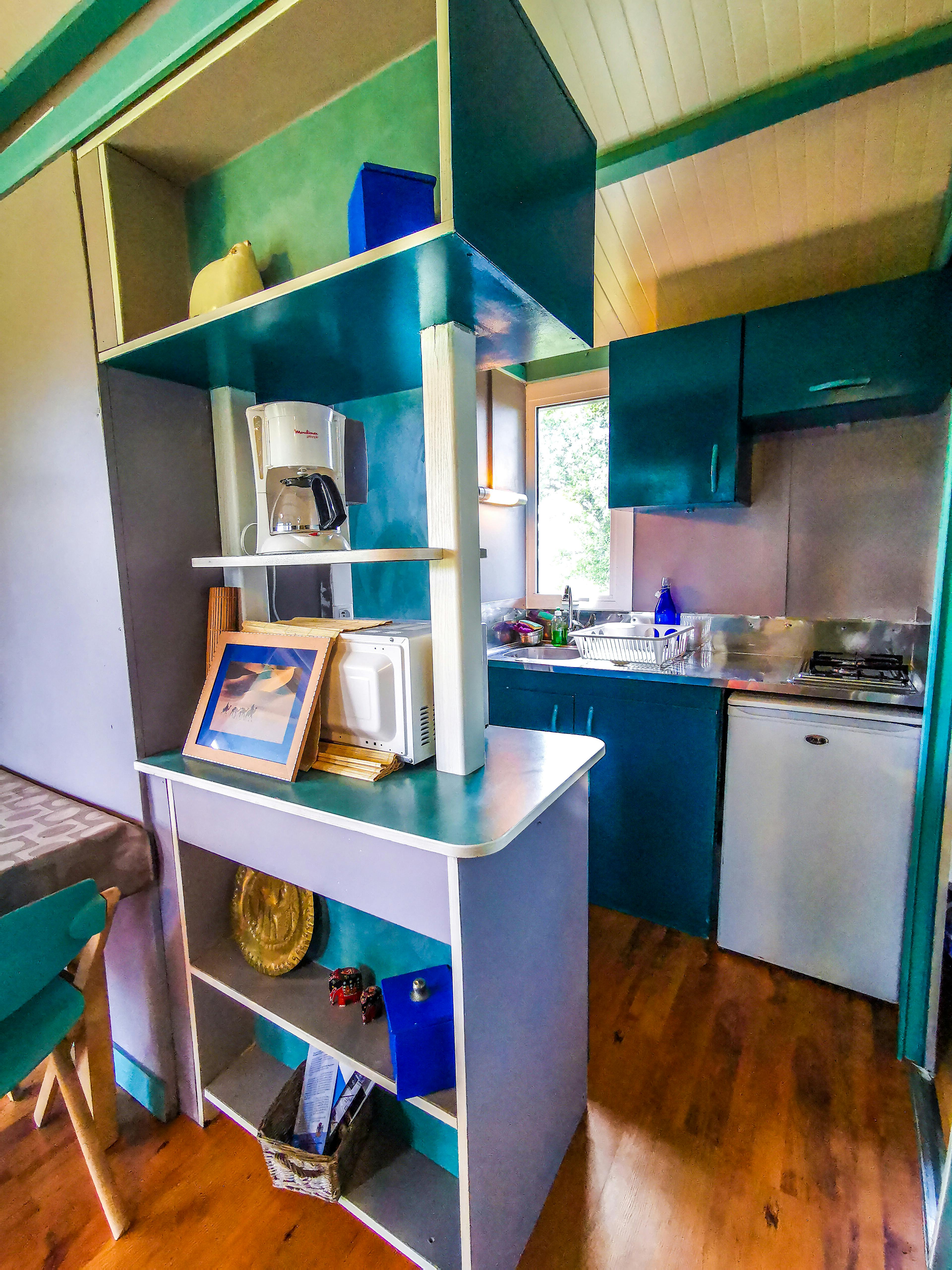 Intérieur du chalet, salle à manger et cuisine équipée.