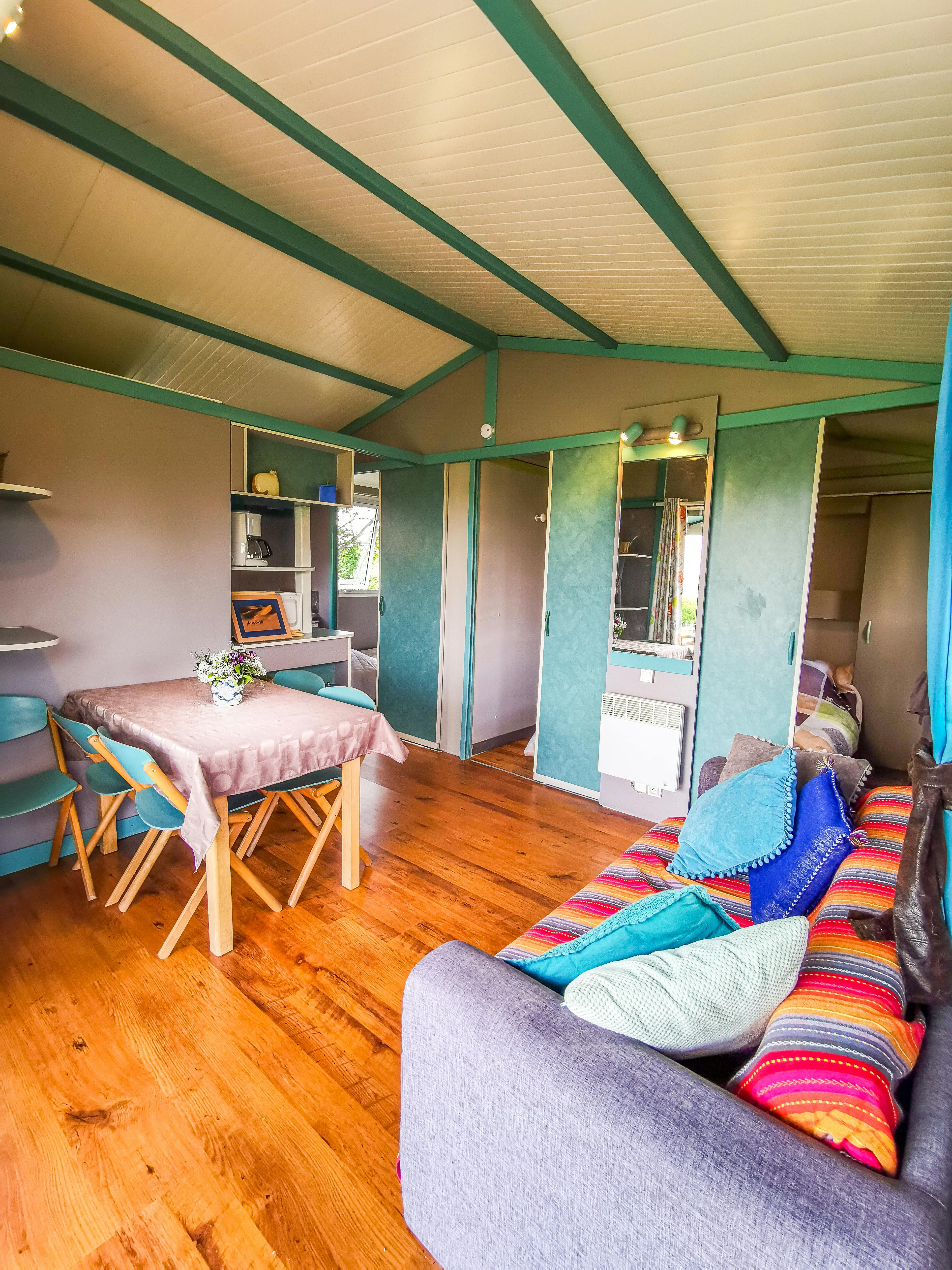 Intérieur du chalet, canapé, salon, salle à manger avec table et chaises.