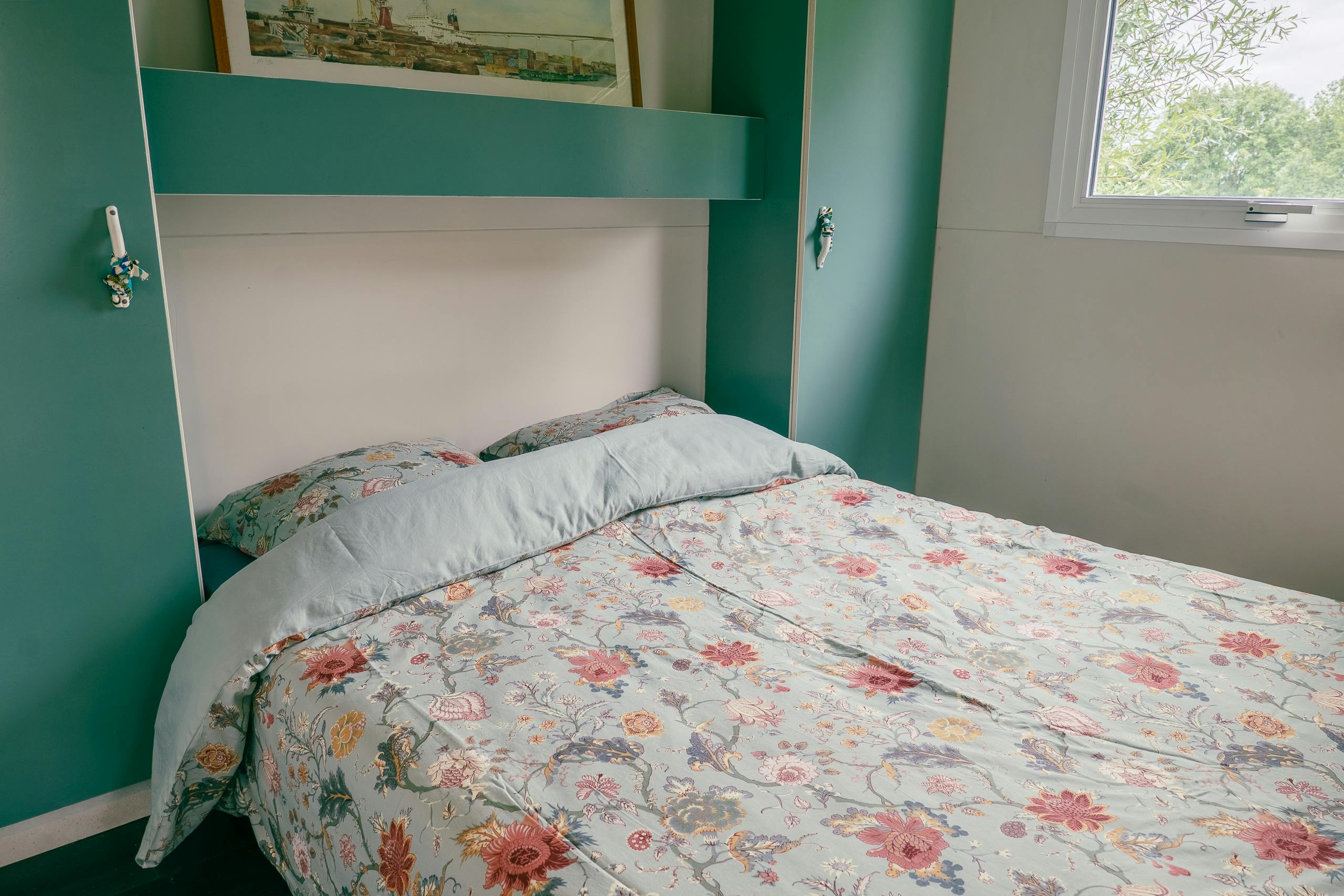 Au-Bonheur-Nomade - vue intérieure de la chambre parentale du chalet marron. Lit double avec rangement