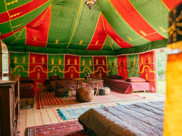 Au-Bonheur-Nomade - vue intérieure de la tente caïdale Marocaine. Plan sur le salon, table, banquette et pouf