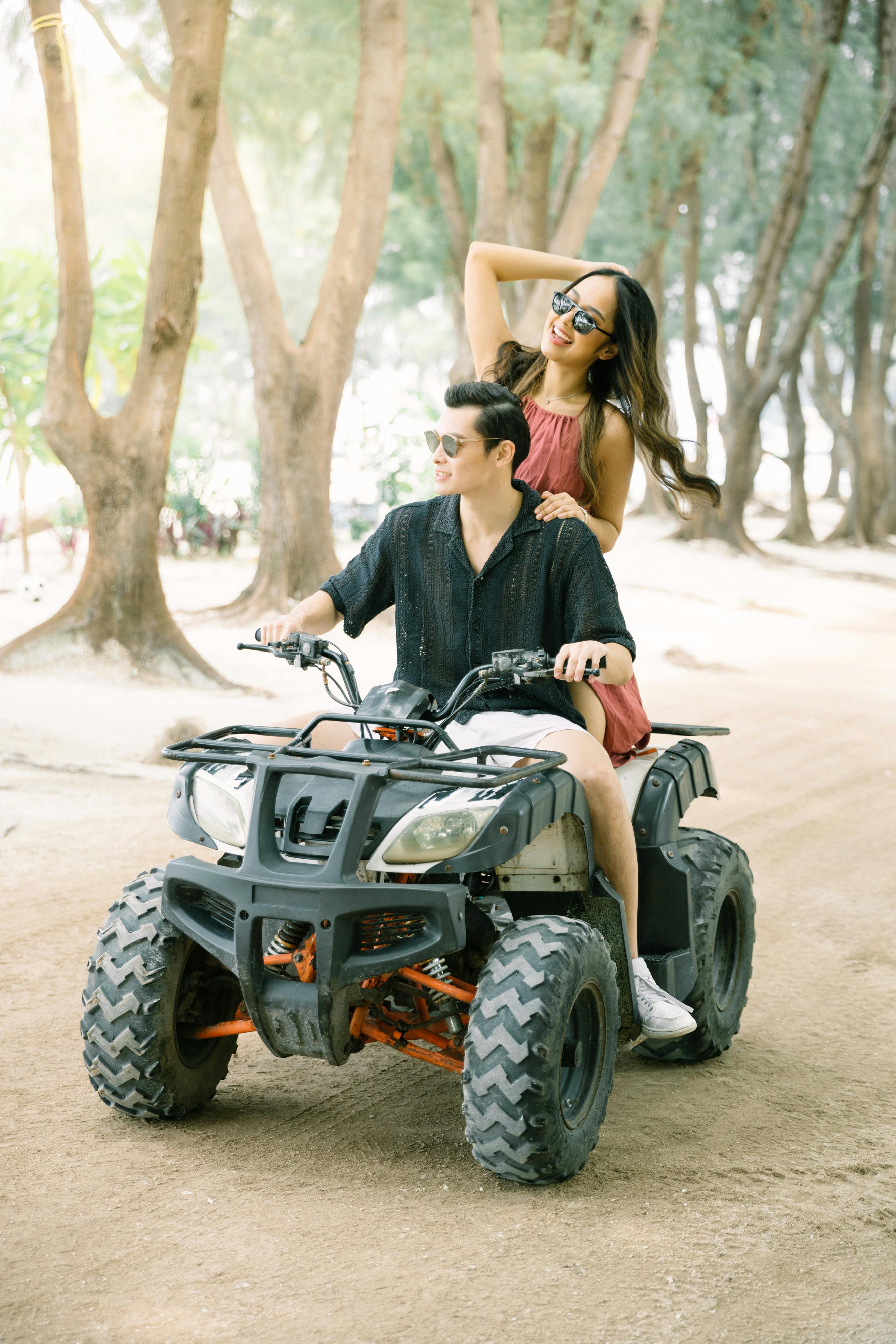 Girl and guy riding ATV on Pulau Payung in Thousand Islands