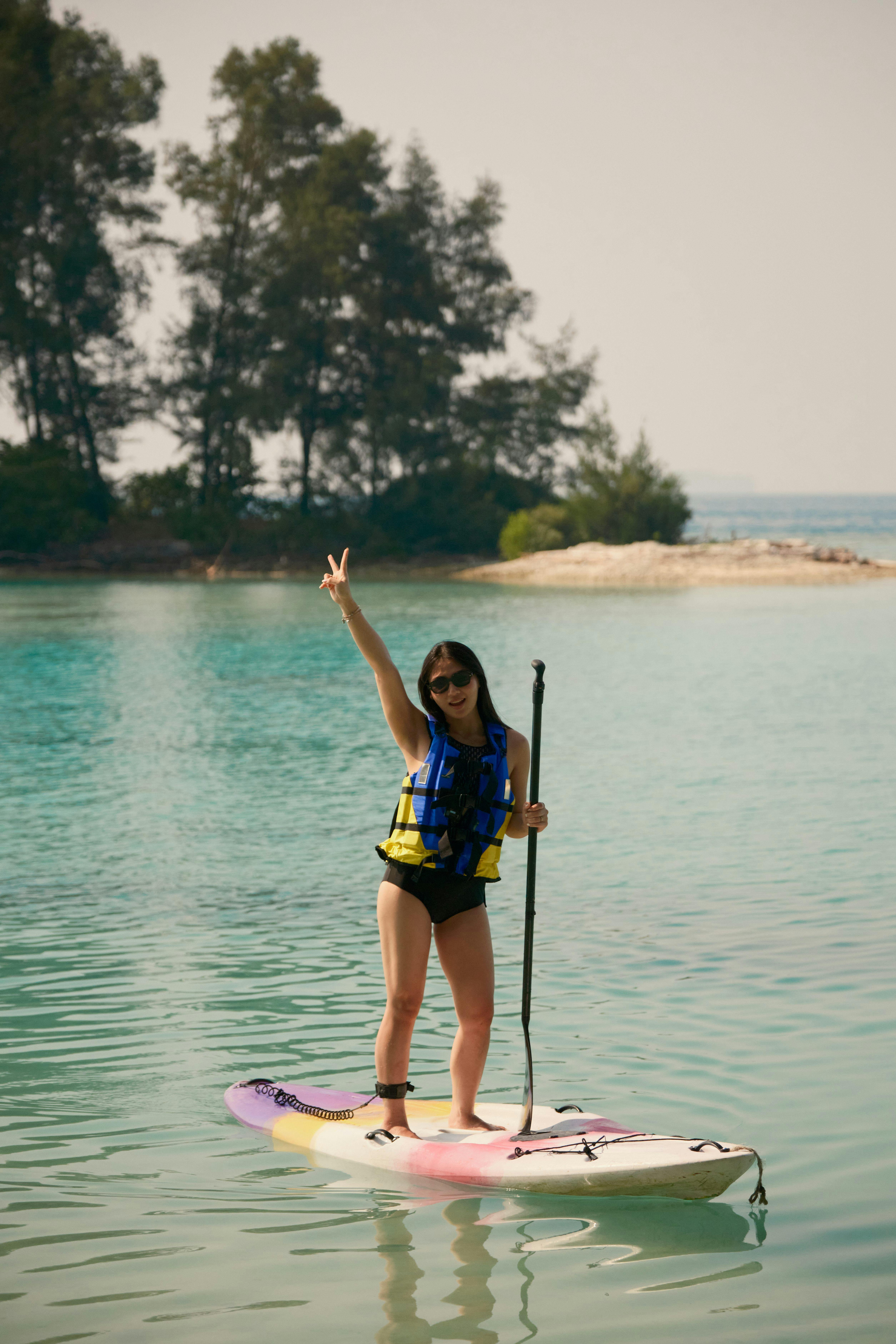 Girl paddle boarding with Batumera in Pulau Payung Lagoon in Thousand Islands