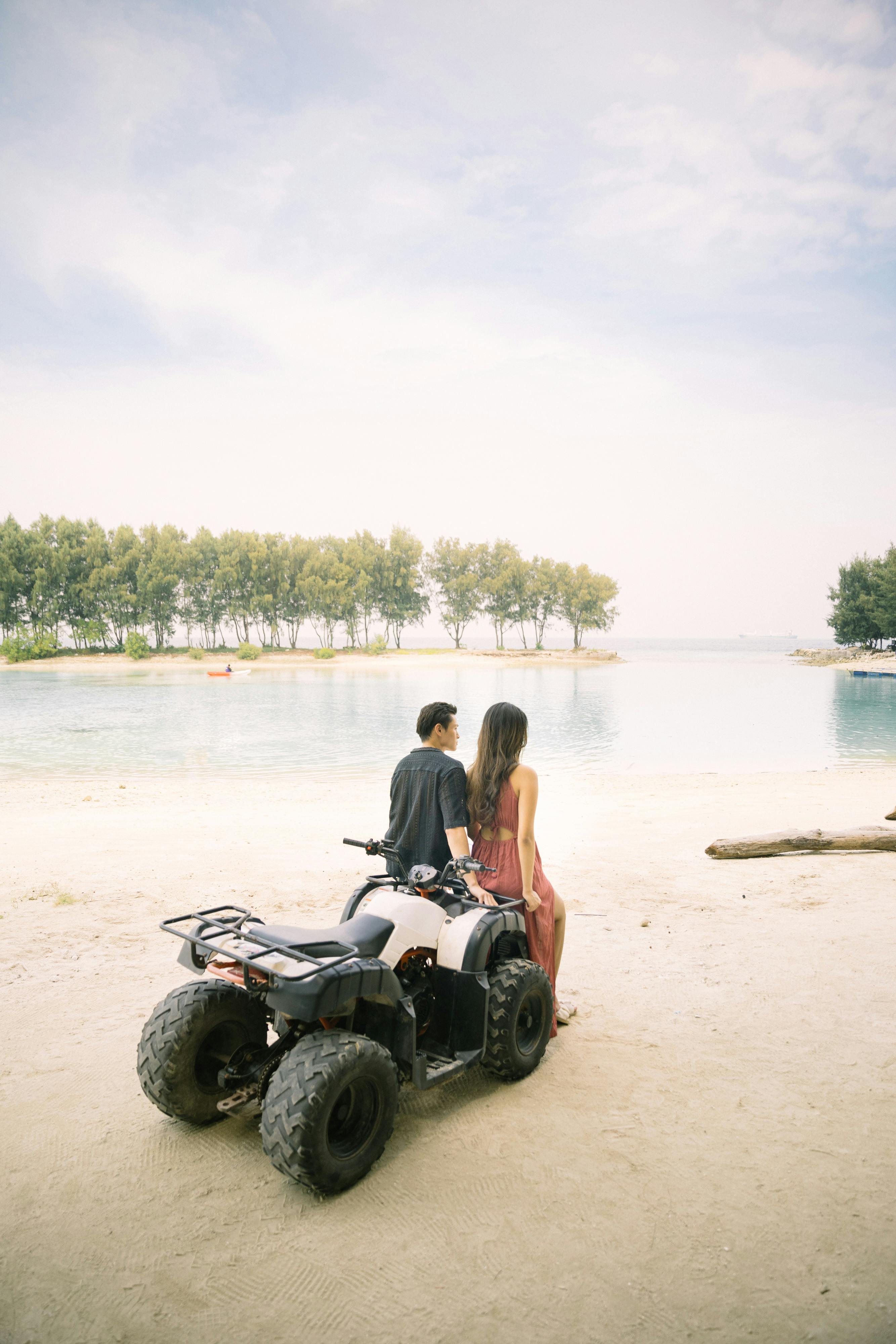 Girl and guy admiring lagoon on ATV on Pulau Payung in Thousand Islands
