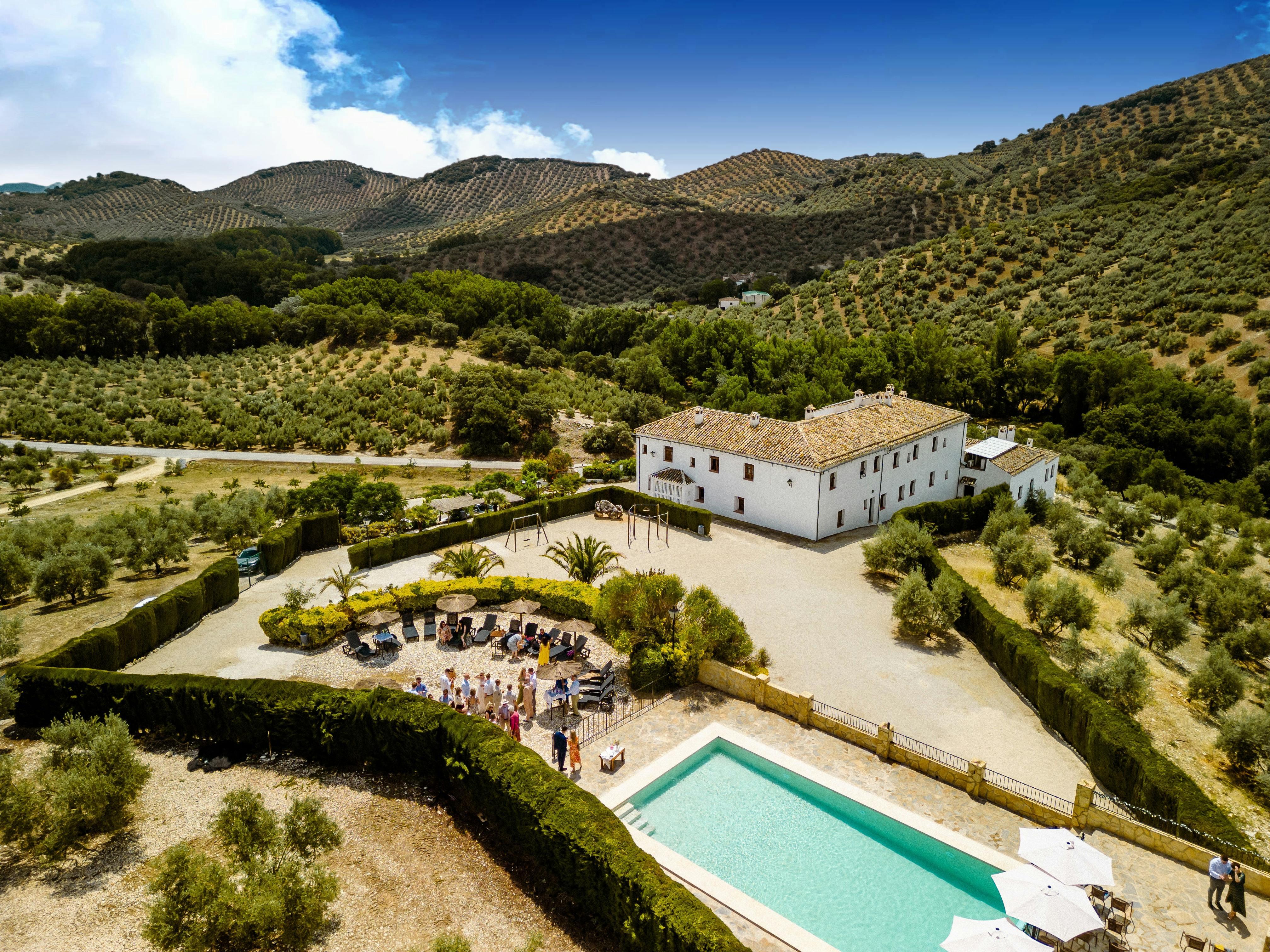Image of the rustic 18th‑century Andalusian farmhouse façade framed by olive trees