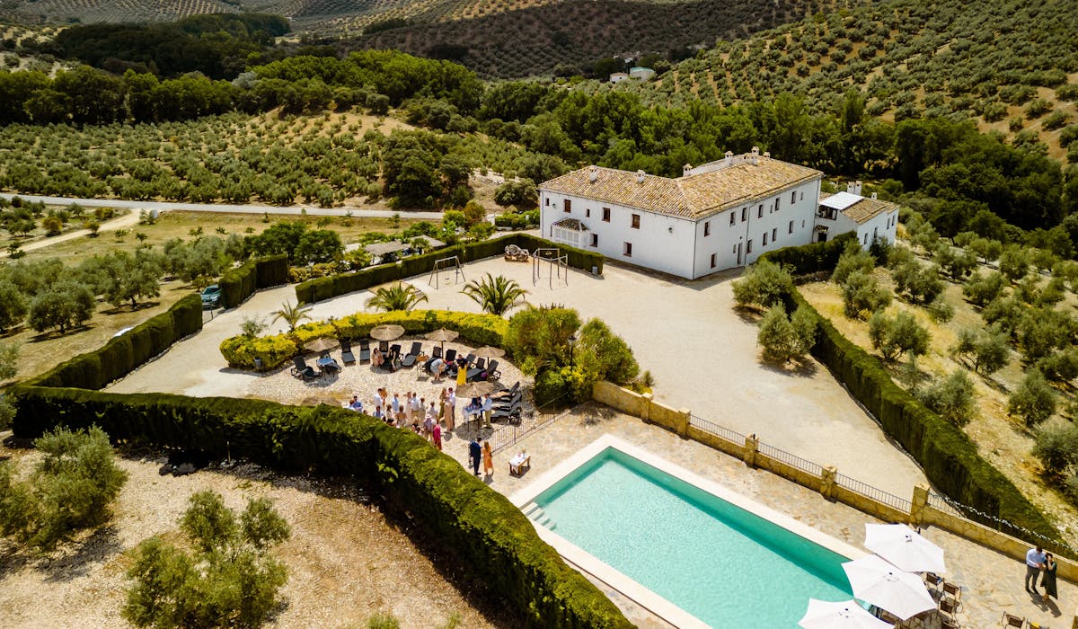 Image of the rustic 18th‑century Andalusian farmhouse façade framed by olive trees