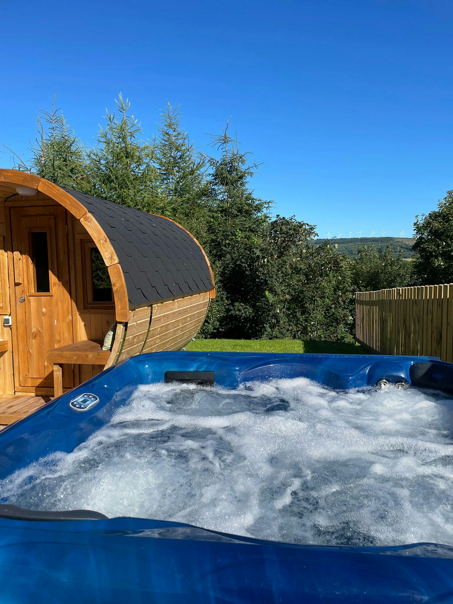 Outdoor hot tub at The Cedar Country Hotel, surrounded by trees.