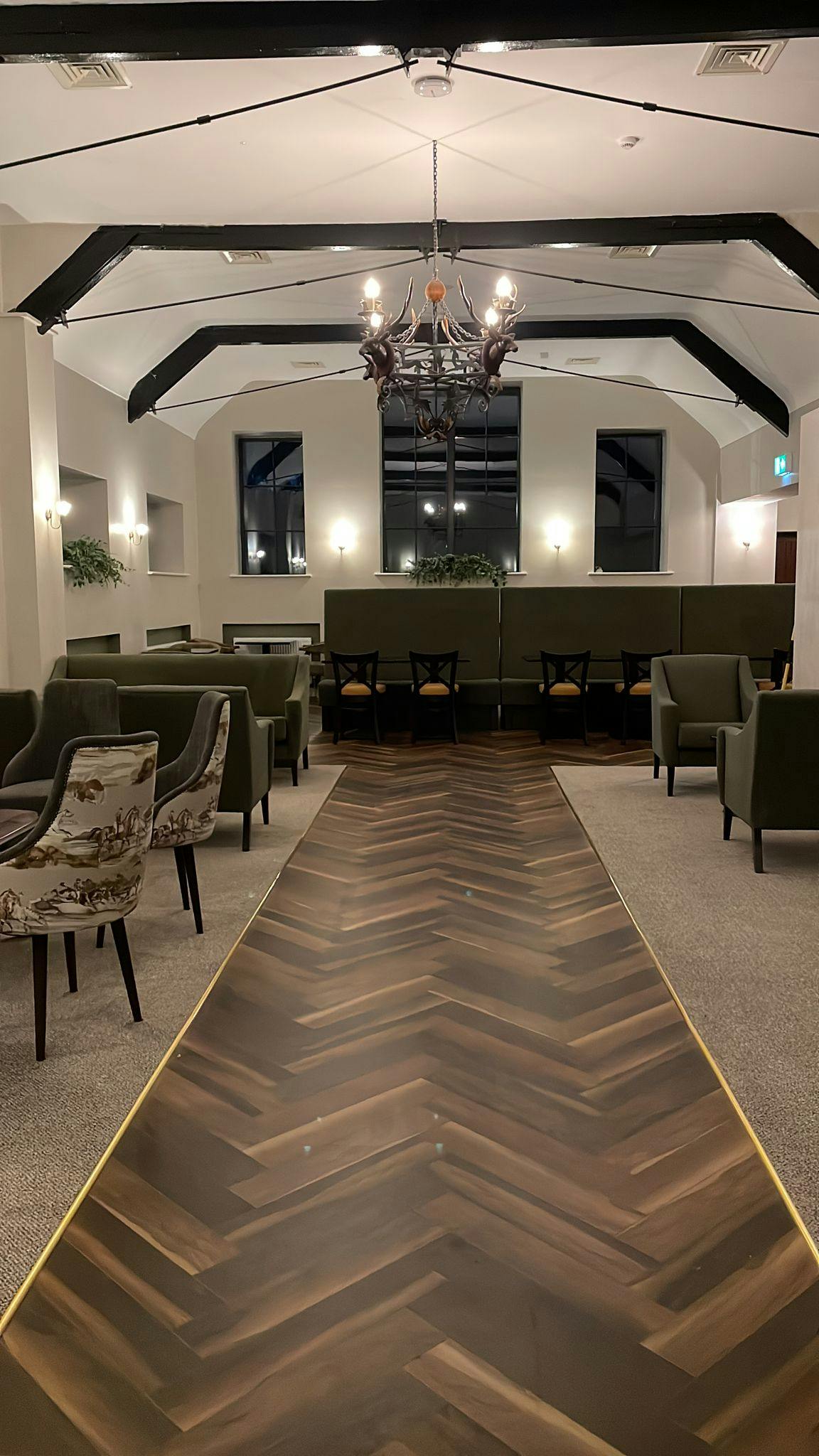 Elegant dining area at Sika 1888 Restaurant, Cedar Country Hotel - featuring high ceilings and Stag chandelier