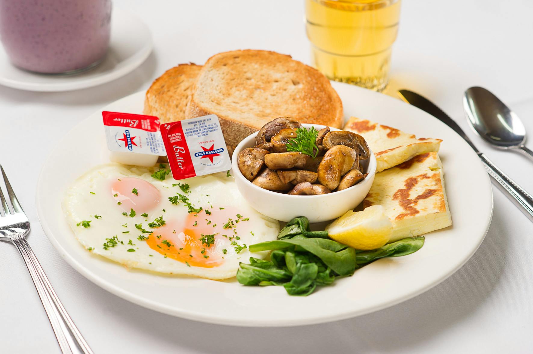 Breakfast plate with eggs, toast, and butter.