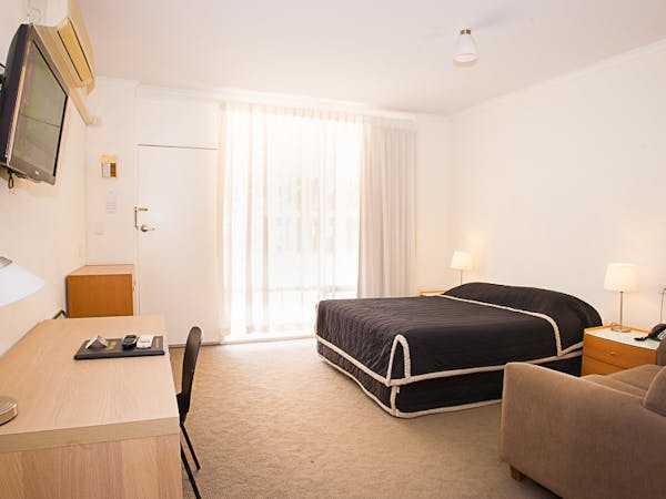 Clean, bright motel room with comfy bed.