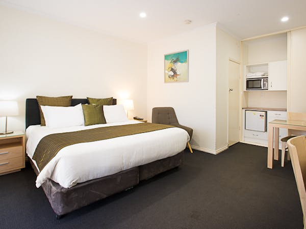 Clean motel room, queen bed, microwave, simple decor, budget-friendly.
