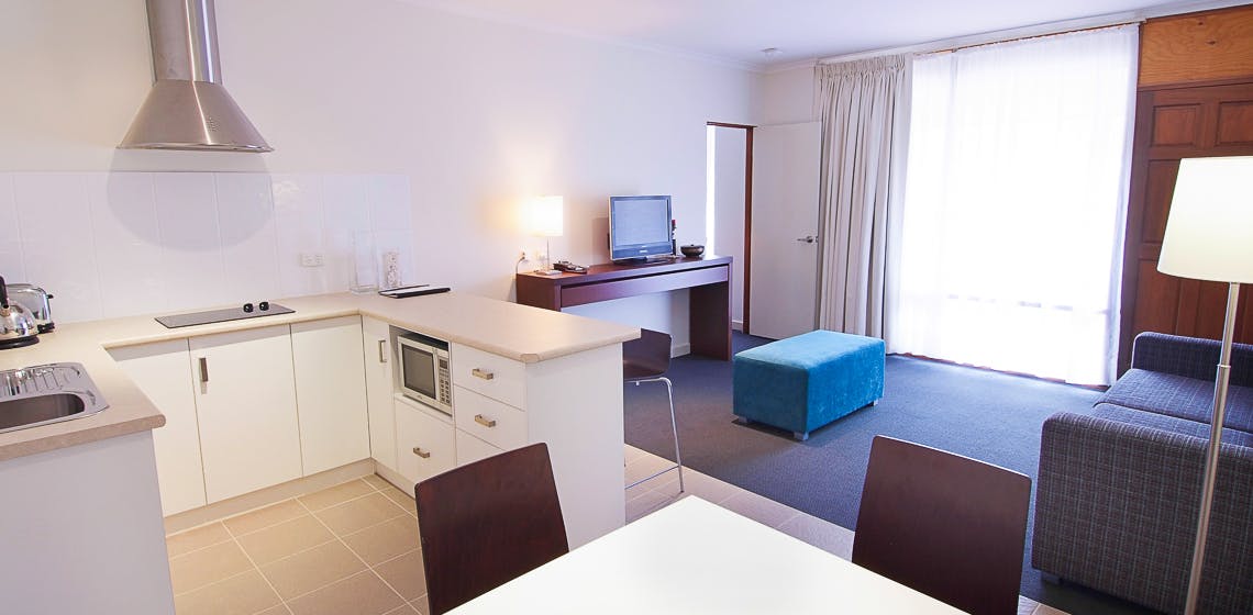 Comfortable and well-equipped studio room featuring a kitchenette and ample natural light.