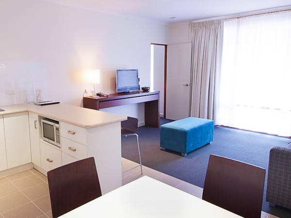 Comfortable and well-equipped studio room featuring a kitchenette and ample natural light.