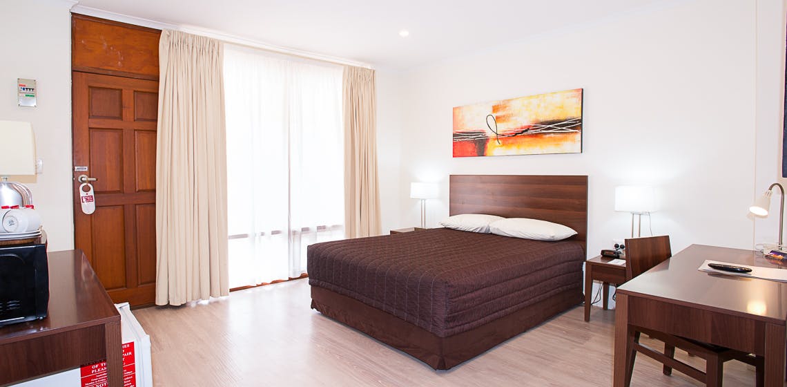 Simple and clean motel room with essential amenities.