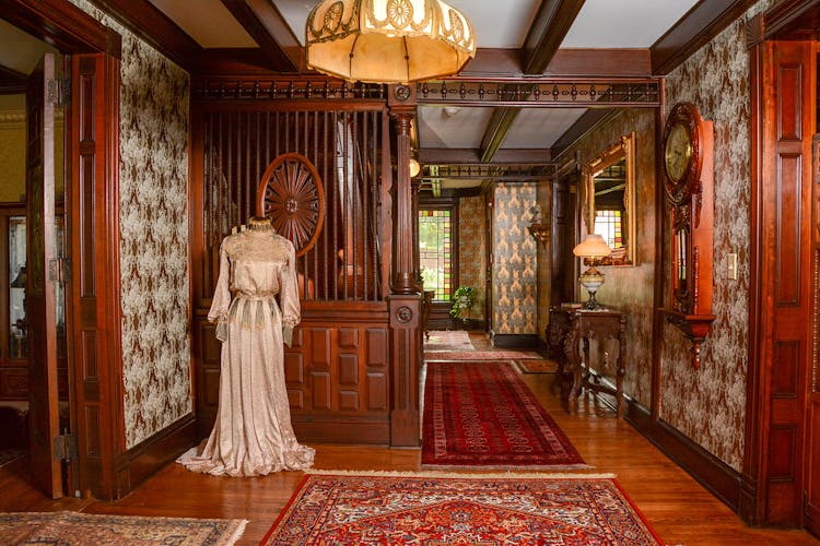 Entry hall with 19th century lady's dress on mannequin.