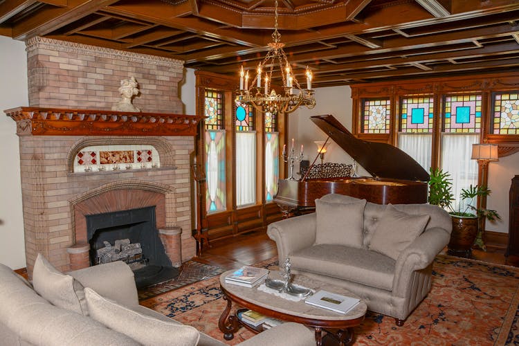 Music room showing fireplace, couches and piano.