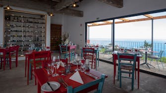 View of inside the restaurant with view of the sea beyond, rustic decoration