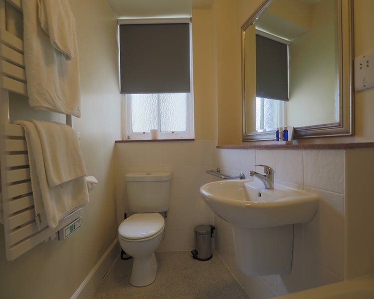 Bathroom with toilet and sink. Towels on a towel rail. Clean and fresh. Royal Hotel, Stornoway, Isle of Lewis
