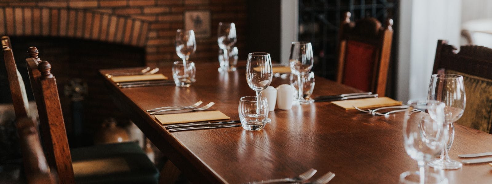 A table set with empty wine glasses and place settings.