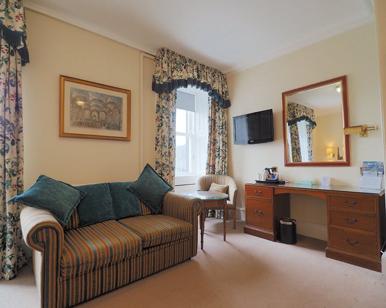 Sofa bed with table and chair. Vanity unity with mirror. Located in the family room in the Royal Hotel Stornoway, Isle of Lew