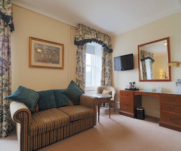 Sofa bed with table and chair. Vanity unity with mirror. Located in the family room in the Royal Hotel Stornoway, Isle of Lew