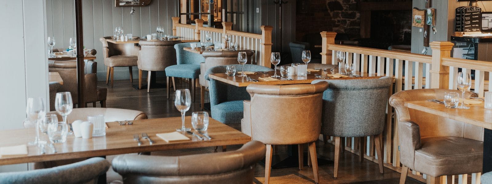 Rustic dining area with wooden tables and chairs in a restaurant.