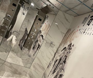 Signature room shower with rainfall head and Chinese landscape tiles