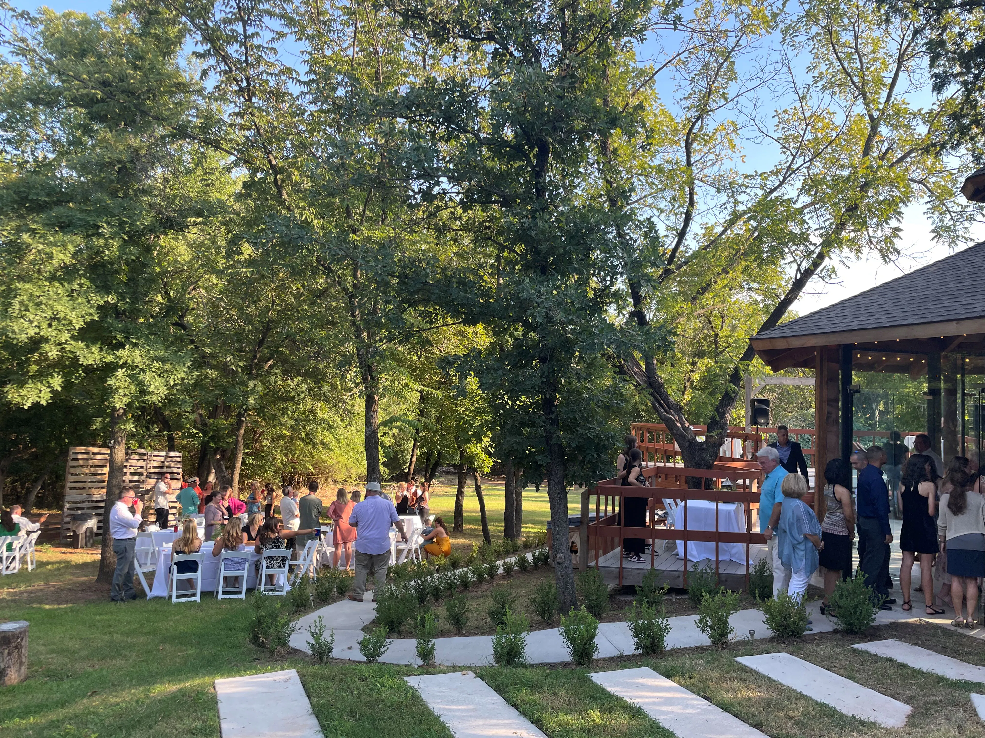 Outdoor wedding reception with guests beside the garden pavilion