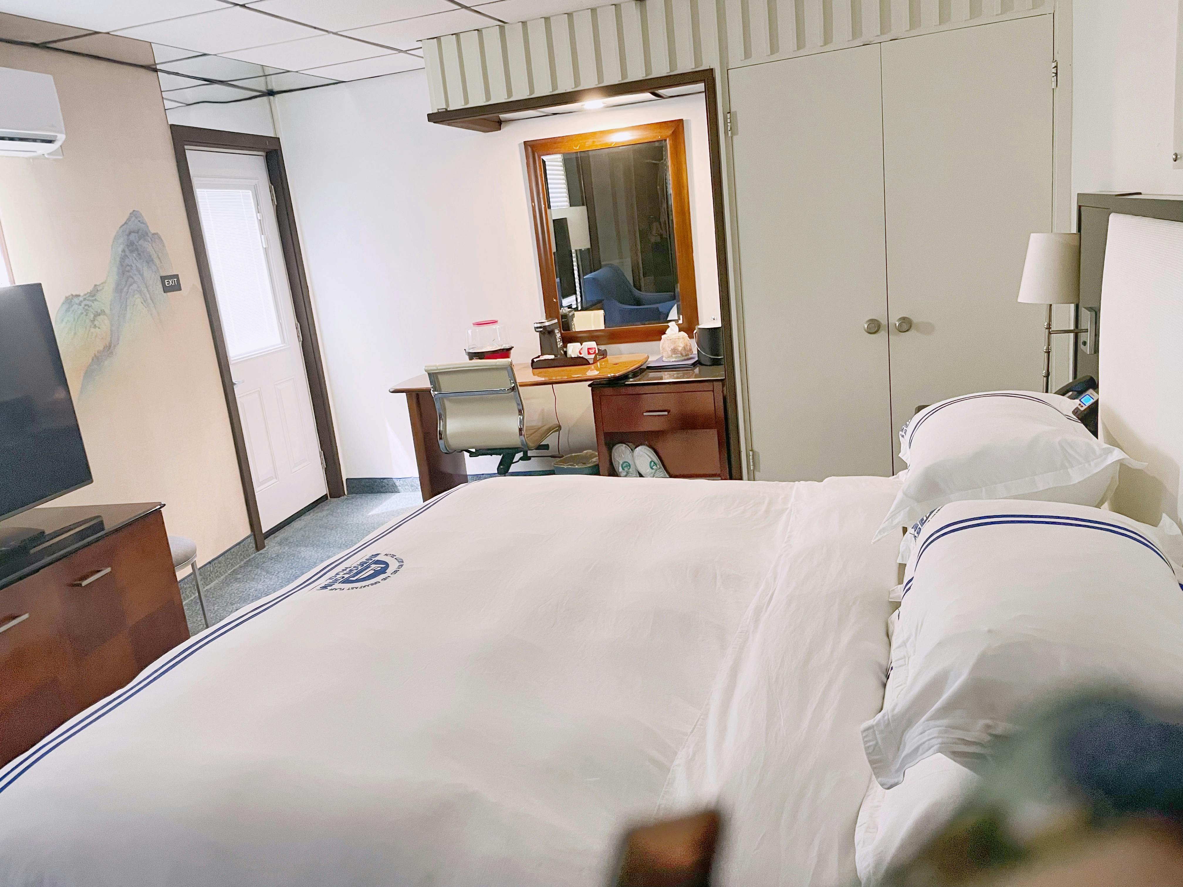 Signature room with king bed, vanity desk and warm lighting