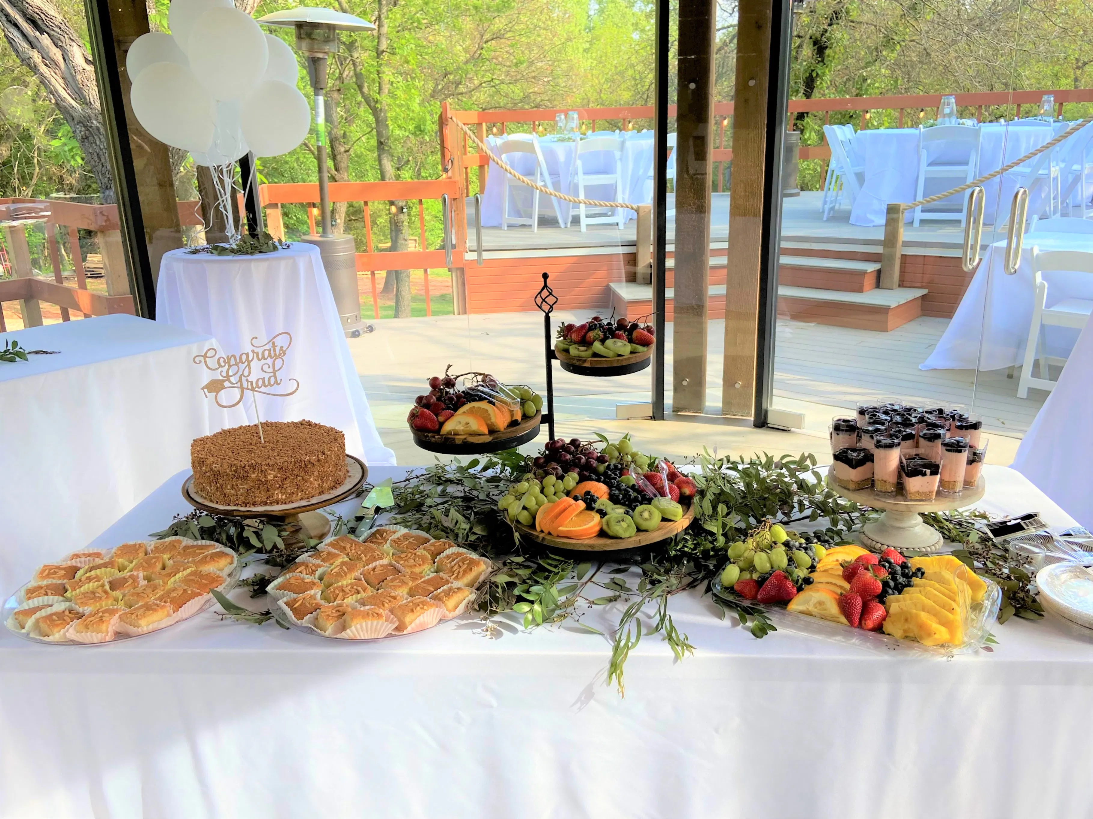 Wedding dessert and fruit table inside the glass pavilion