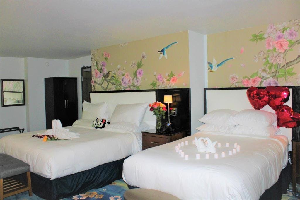 Spacious room with one king bed and one XL bed, featuring a massage bathtub and separate shower – Wang Shi China Palace OKC