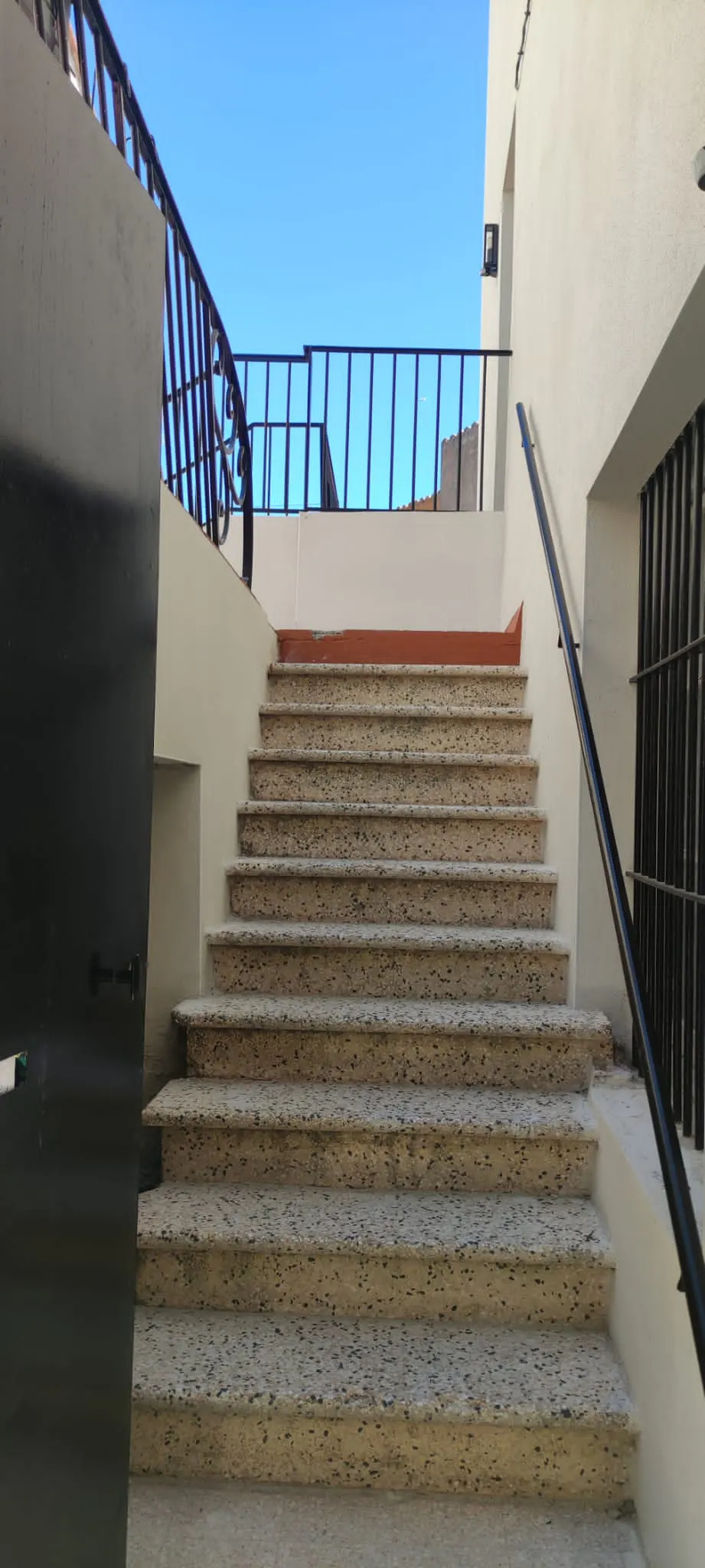 Escalier après la porte d'entrée donnant sur la rue