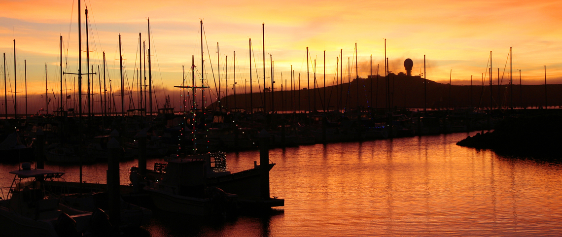 Sunset behind ship masts in Pillar Point Harbor