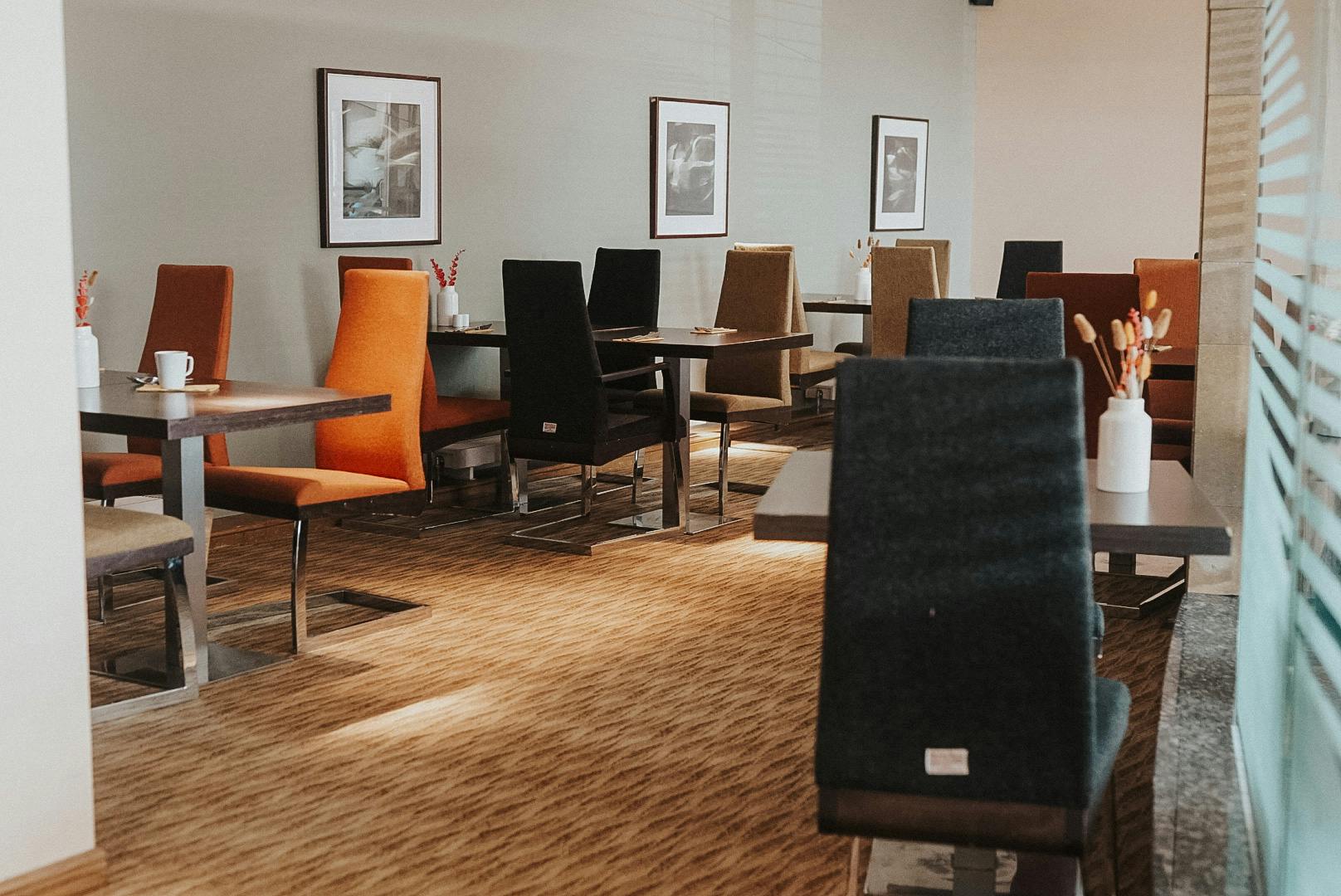 A vibrant dining area in Cabarfeidh Hotel with an array of tables and chairs for a cosy dining experience.