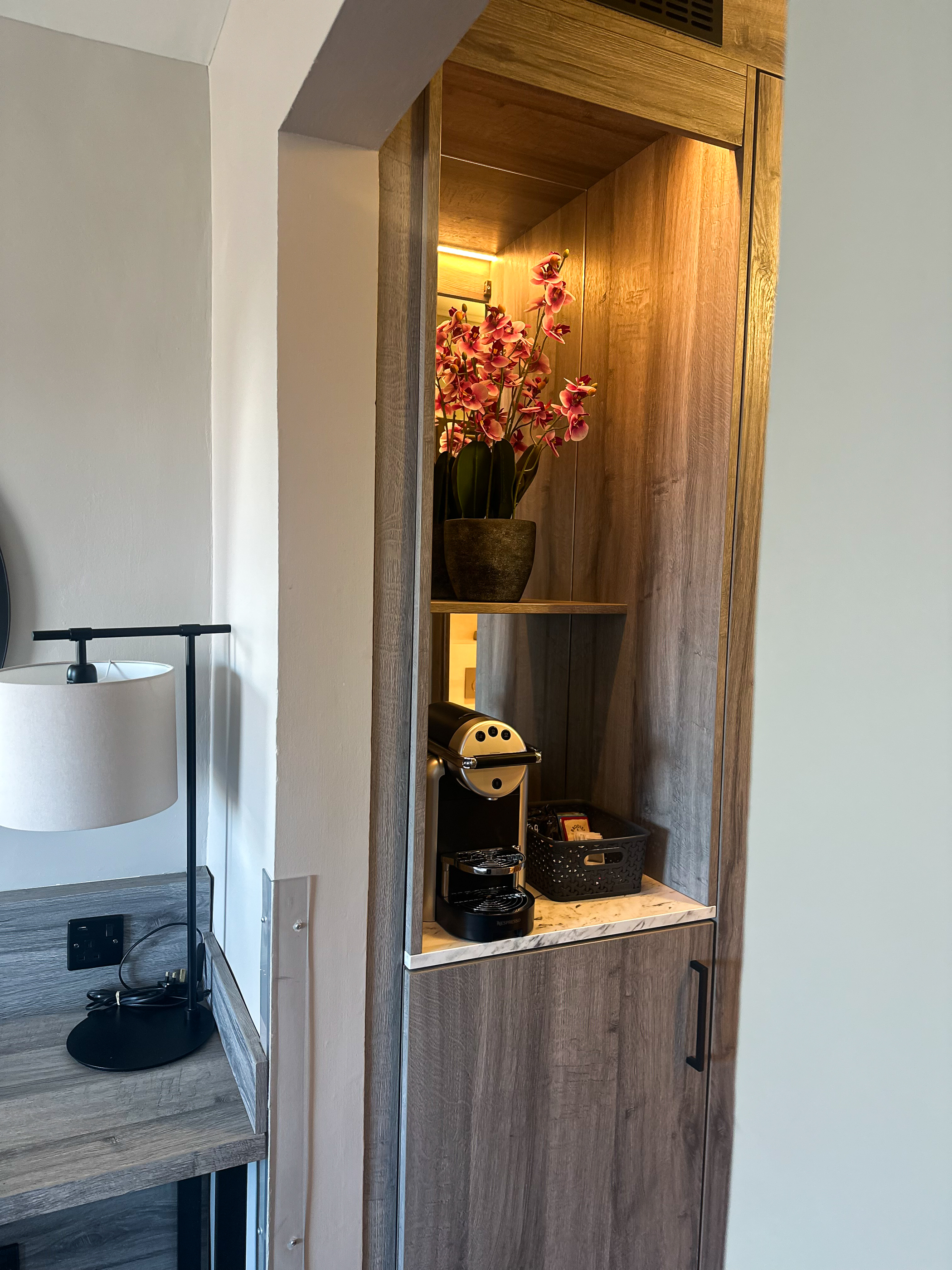 Shelf in the executive room at Cabarfeidh Hotel featuring a coffee maker and a green plant.